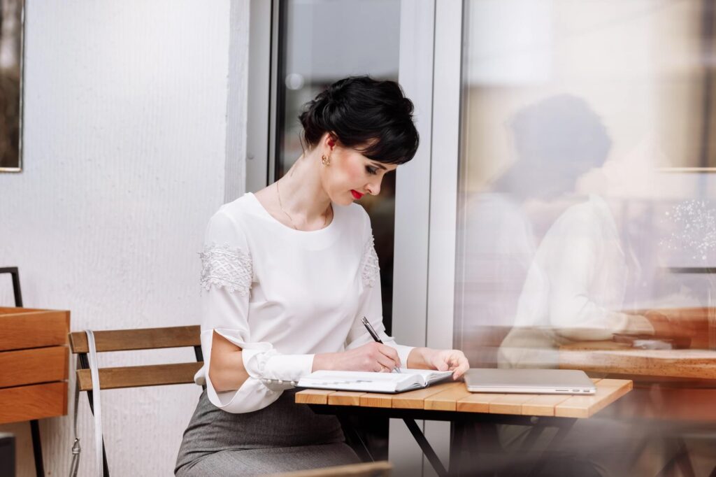 Businesswoman writing notes on notepad